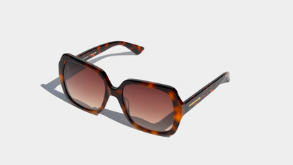 Angled front view of havana brown patten butterfly style frame sunglasses with amber square lenses