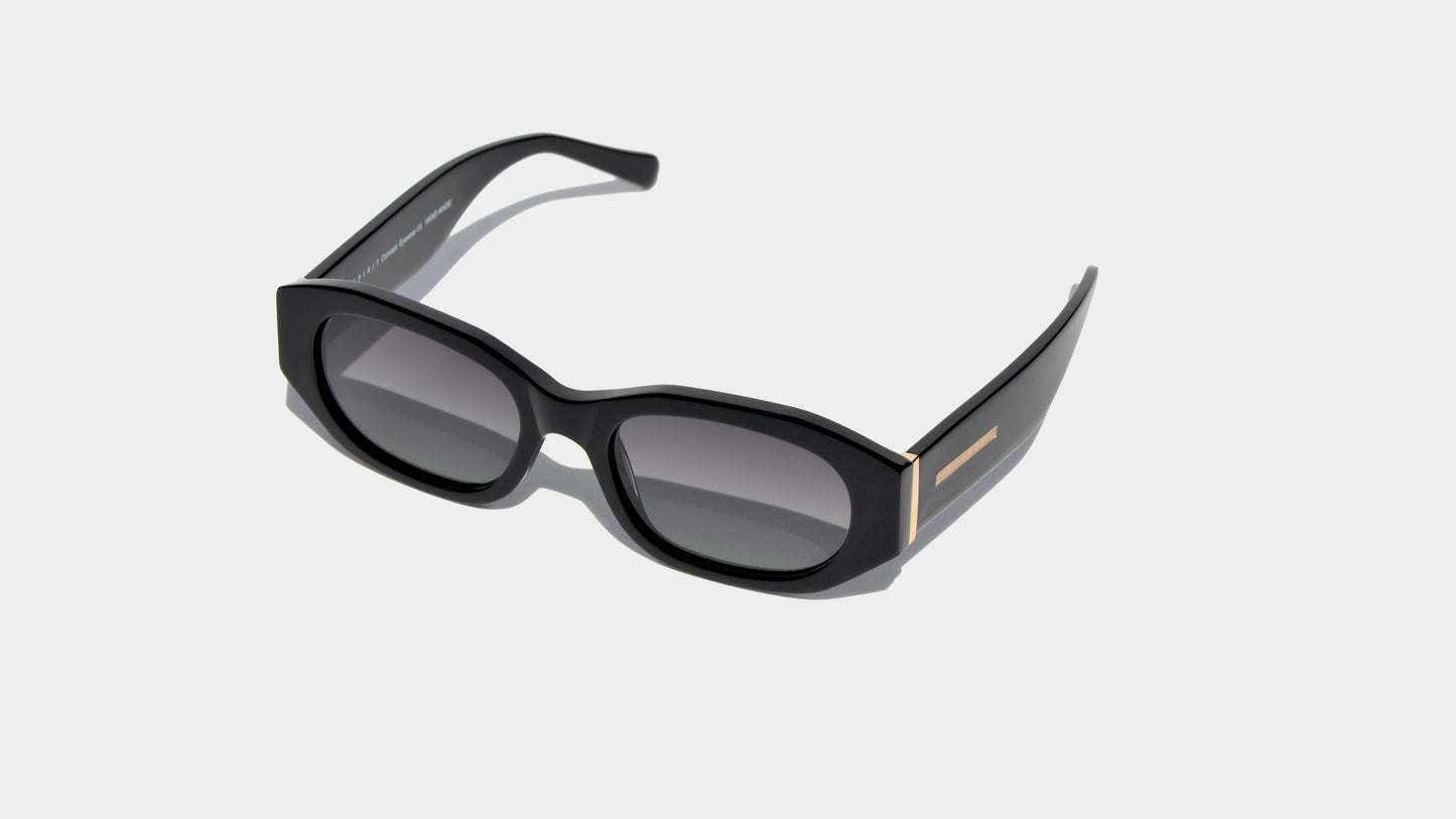 Angled front view of shiny rectangle frame sunglasses with narrow grey lenses