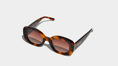 Angled front view of havana brown rounded cat eye frame sunglasses with amber oval lenses