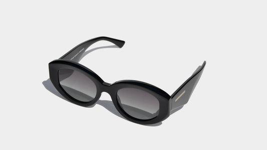 Angled front view of black rectangle frame sunglasses with grey oval lenses