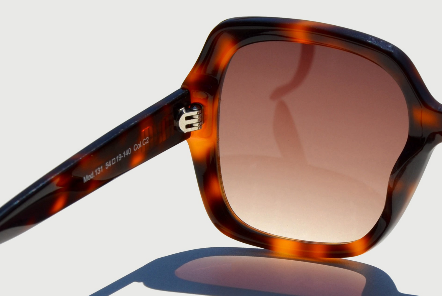 Close up left brown lens havana brown pattern sunglasses hinge and arm extended out