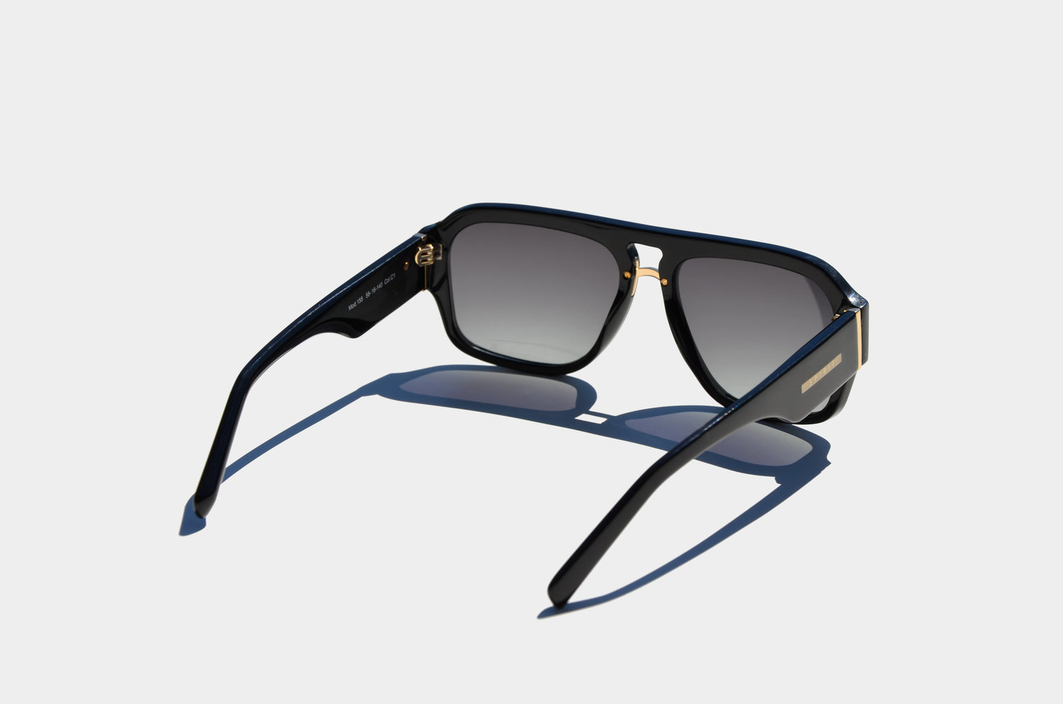 black double bridge sunglasses facing away showing behind square grey lenses and arms extended outward