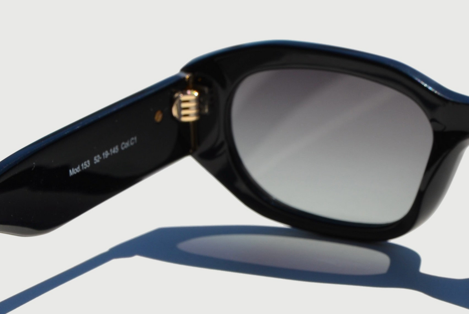 Close up hinge on black rectangular sunglasses and lens 