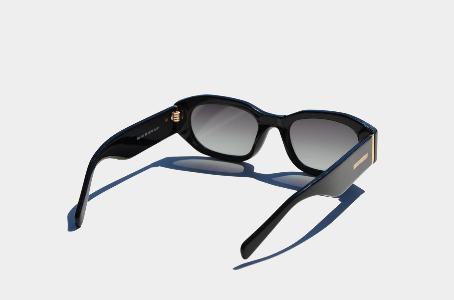 Black rectangular sunglasses with gradient grey lenses, featuring gold SPIRIT plaque angled away