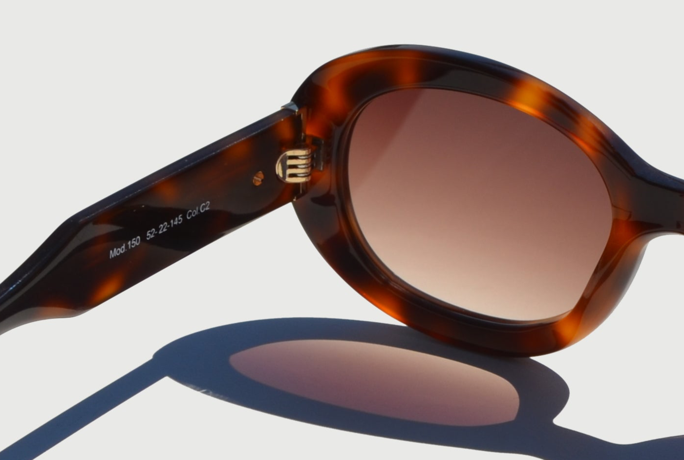 Close up of Havana brown sunglasses arm showing hinge detail and brown oval lens