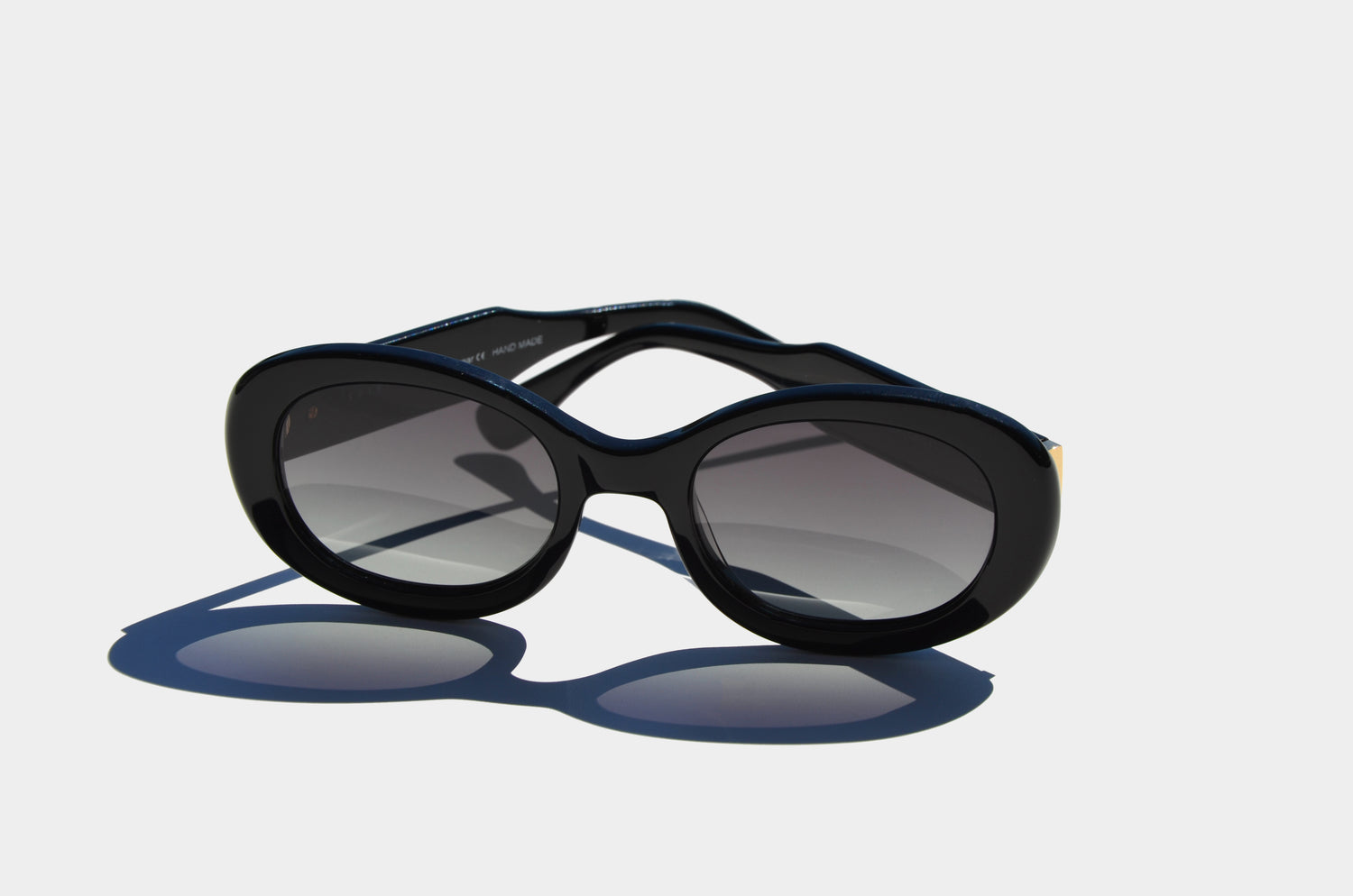 Black round frame sunglasses with gradient grey lenses temple arms folded behind