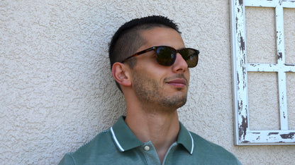 Good looking man wearing Merhoki Astor wayfarer eyewear, standing by vintage white frame.