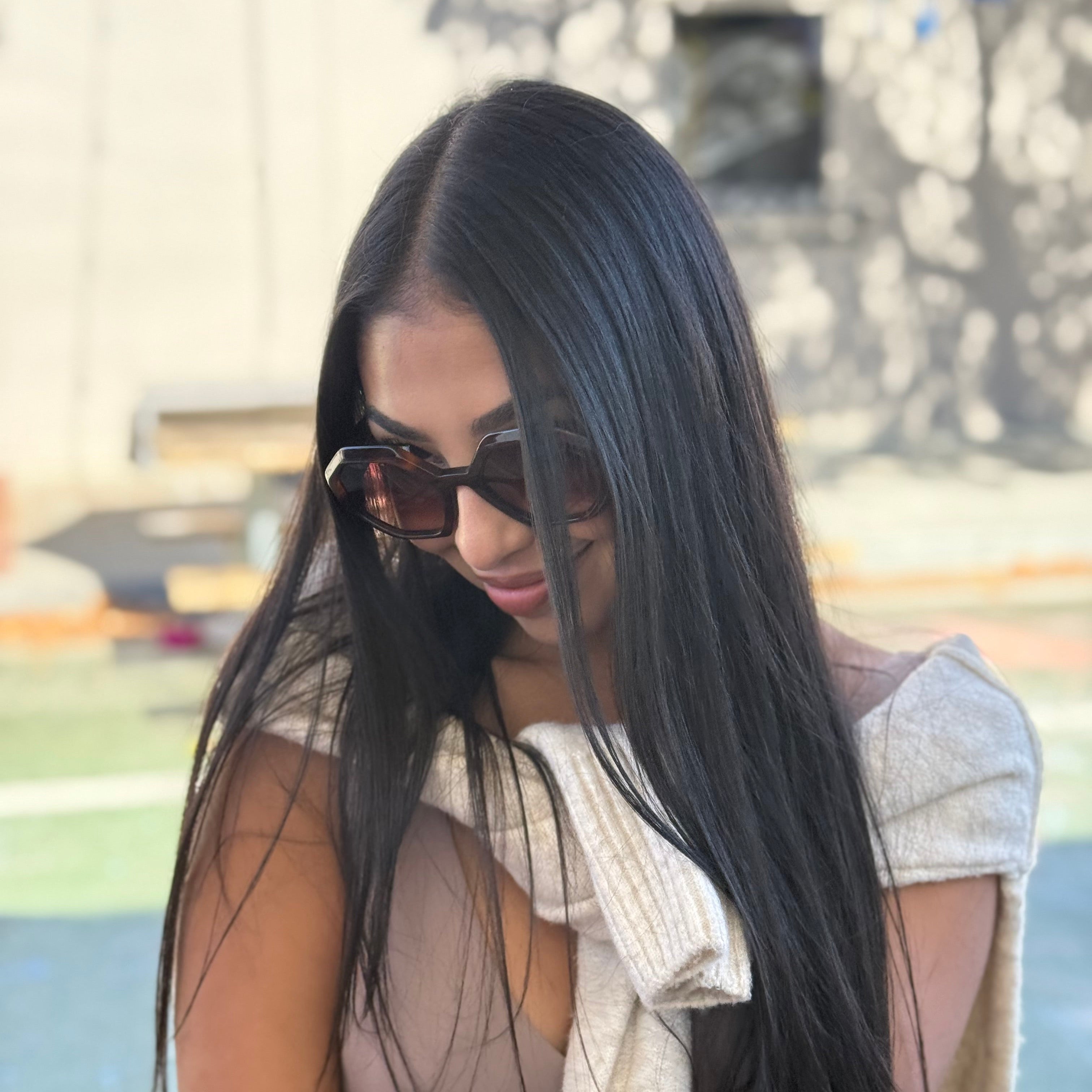 Woman posing with cute brown designer sunglasses.