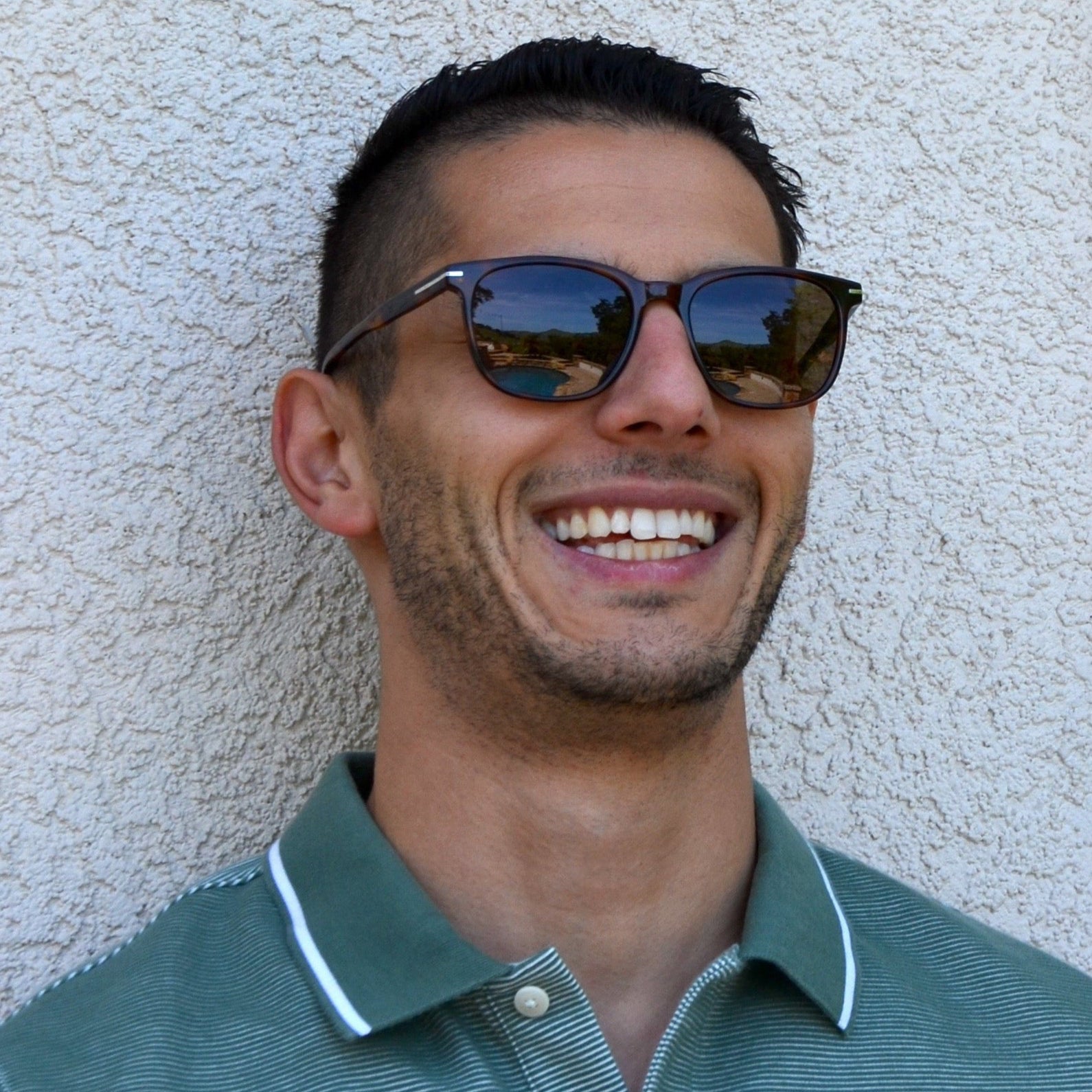 Man looking happy wearing lightweight wayfarers for cool day style.