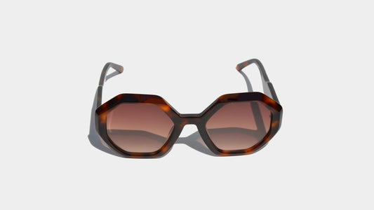 Front view of Havana brown eyewear with bold geometric frames and oversized gradient amber lenses, blending retro-futurism with Milan style.