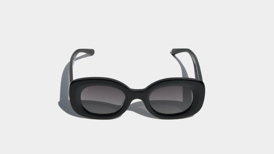 Front view of shiny black Jacky oval cat-eye sunglasses, showcasing sleek polished frames and elegant gradient lenses.